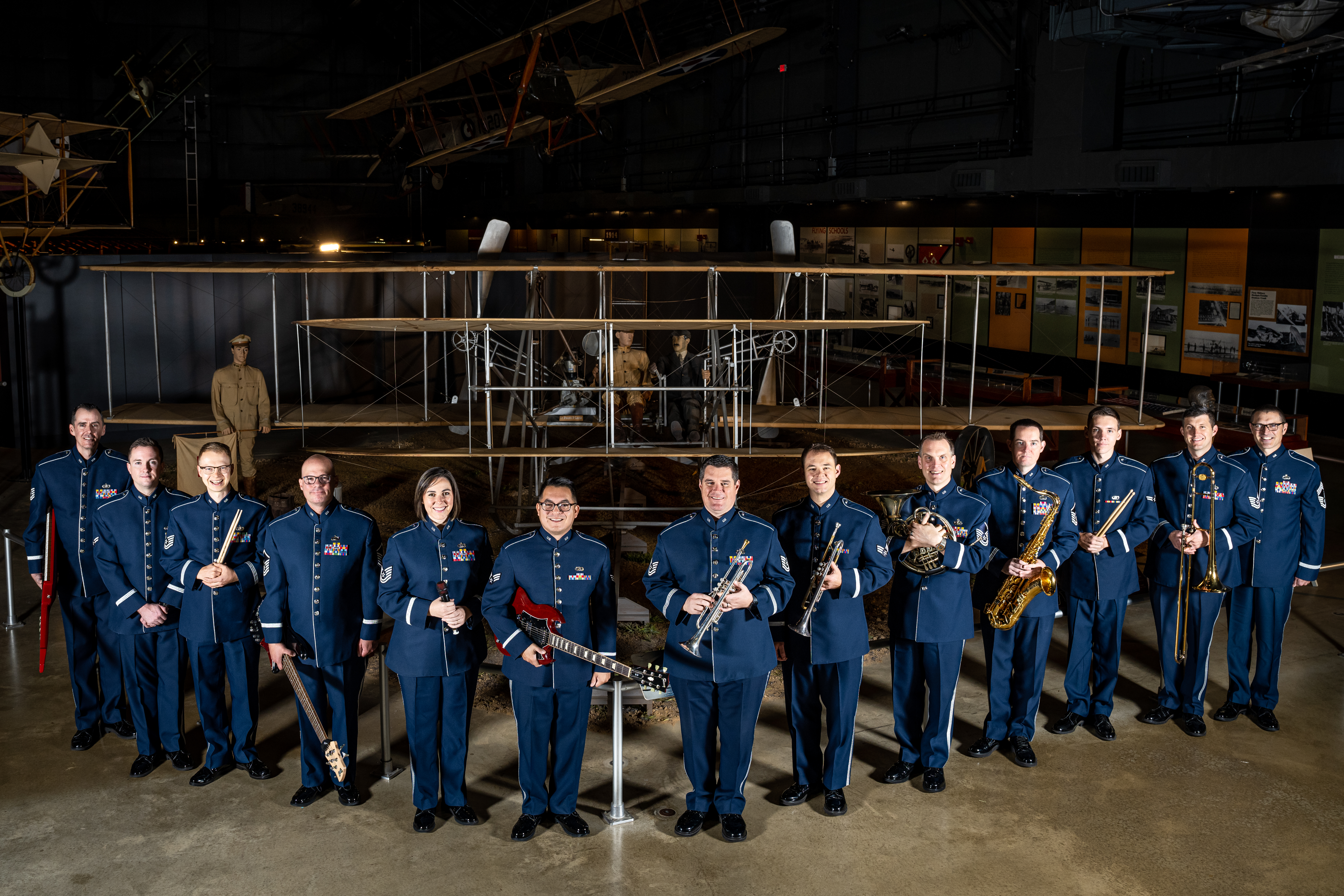 The Band of Flight poses together in the Air Force Museum holding their instruments.